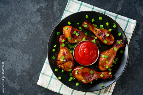 Wallpaper Mural Fried chicken legs with sauce on a black table,  top view. Roast chicken drumsticks with ketchup. Torontodigital.ca