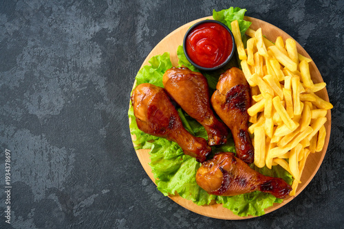 Wallpaper Mural Fried crispy chicken legs with ketchup and french fry on a black table, top view. Torontodigital.ca
