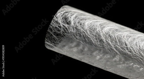 closeup of a roll of white fibers on a cylindrical object
