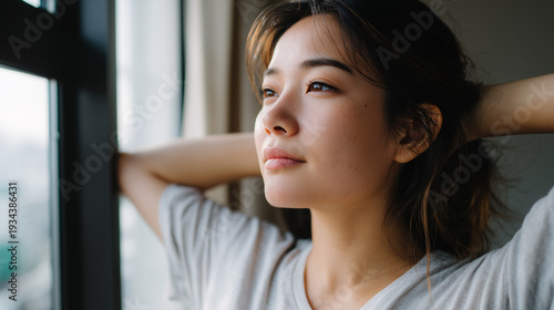 Woman stretching by window in soft morning sunlight Free Download Woman stretching by window in soft morning sunlight - GFXLoad