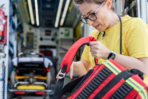 Bilde på lerret Paramedic preparing medical bag in ambulance: emergency service
