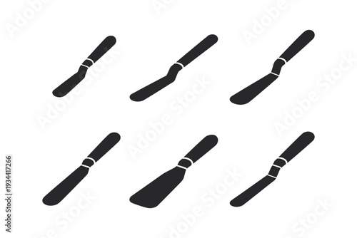 Set of six black palette knives and spatulas on a white background