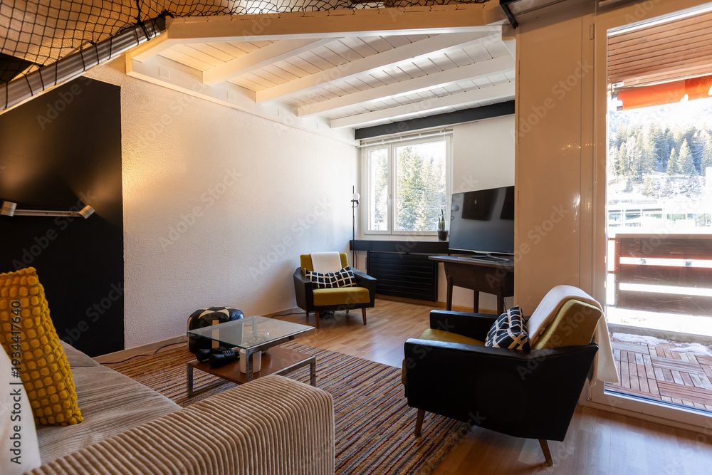 Obraz premium Living room with sofa, two armchairs, and cushions. There's a small balcony overlooking the Swiss mountains. Interior of a mountain chalet.