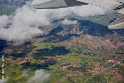 aerial perspective,captured moments before landing at Alejandro Velasco Astete International Airport, offers a first glimpse of the rugged beauty and agricultural heritage surrounding Cusco, Peru. 