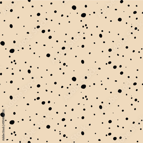 Seamless minimalist speckled pattern with irregular black dots on a beige background.