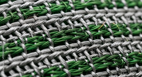 A close up view of a woven fabric with interlacing green and gray threads creating a textured pattern