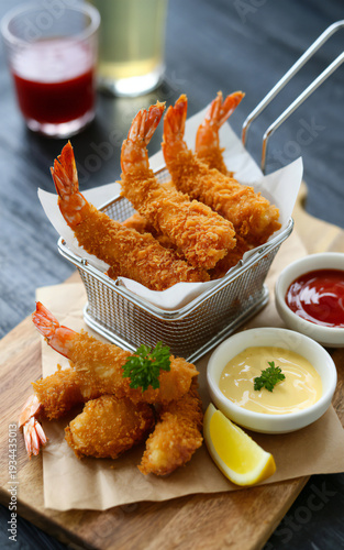 Delicious fried shrimp and calamari with dipping sauces on a wooden board