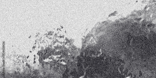 Abstract grayscale textured background with a dense, irregular cluster of dark gray shapes and specks on a lighter, grainy surface, suggesting organic growth or cellular structures