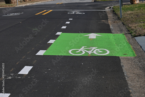 Green paint with white bicycle symbol and arrow for bike lane on road