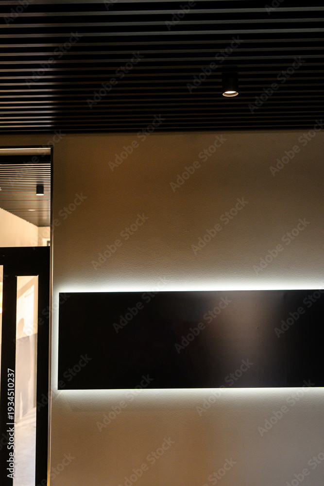 Obraz premium Modern interior wall with illuminated panel and sleek ceiling design