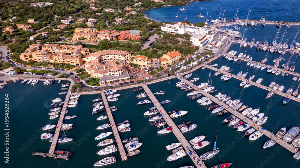 Obraz premium Luxury yachting lifestyle in Porto Cervo marina aerial drone view . Expensive speedboats and sailing ships in turquoise bay. Wealthy summer vacation in Italy