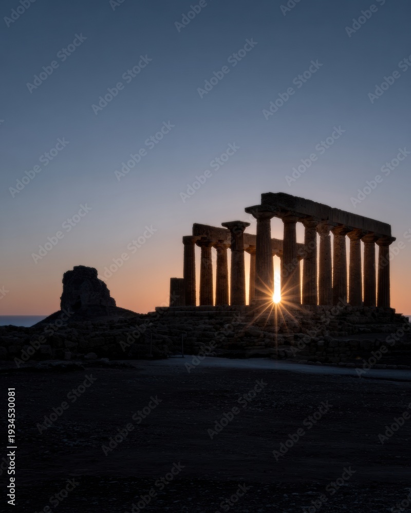 Obraz premium Ancient Roman temple ruins featuring stone columns silhouetted against a vibrant sunset sky for Mediterranean travel and historical heritage site tourism background