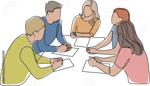 A group of people sitting around a table with papers