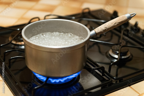 Obraz na płótnie Eau qui bout dans une vielle casserole qui chauffe sur une gazinière, avec des f