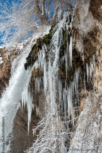Large icicles and other ice formations adorn waterfalls at Rifle Falls State Park in Western Colorado on clear cold winter morning..