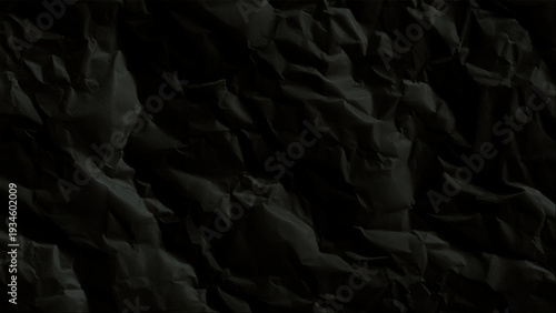 Crumpled black paper texture background surface closeup