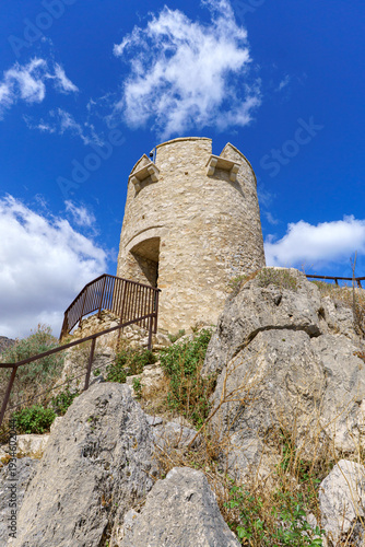 Dramatic Low-Angle View of the Ancient Stone Torre Bennistra Watchtower on its Rocky Summit, Scopello, Sicily