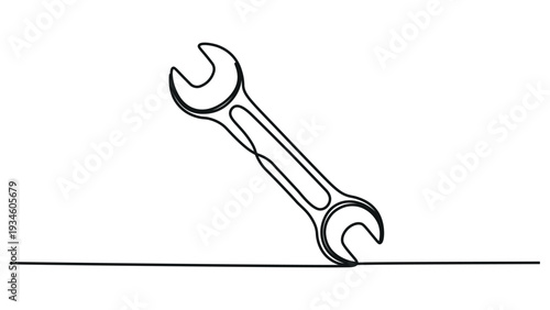 A double-ended wrench sitting on a flat surface