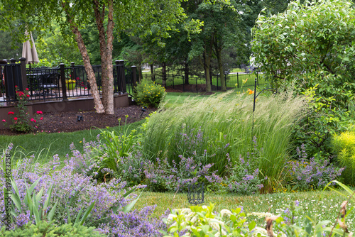 Tall, columnar, low maintenance and drought resistant, Karl Foerster Feather reed grasses are a beautiful living fence providing privacy and tranquility in this lush backyard retreat.  