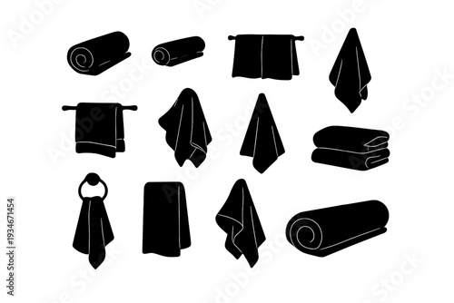 Collection of rolled and hanging towels in various shapes on a white