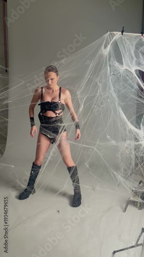 Woman in Spiderweb Posing for Halloween Fashion Shoot