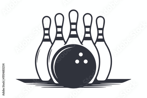 A black and white bowling ball sits before the arranged bowling pins on lane