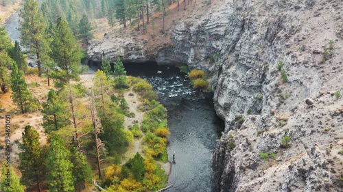 Aerial drone clip over and evergreen forest and river in the American West.