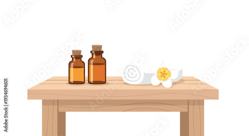 Two amber glass bottles of essential oils and a rolled white towel with a frangipani flower are neatly arranged on a light wooden table.