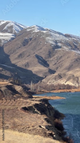Shamb Reservoir in Armenia surrounded by rugged mountains and winter snow patches under clear blue sky. Scenic highland landscape and freshwater lake concept for travel, nature