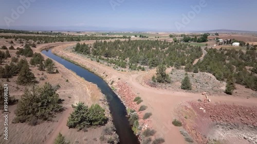 Aerial drone footage of an irrigation canal with water in the arid western U.S.