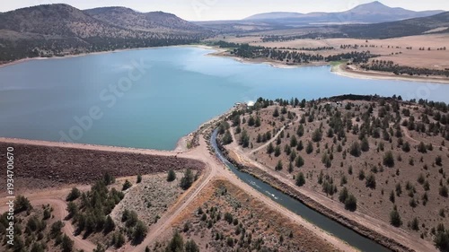 Aerial drone footage over a nearly full reservoir in an arid western landscape.