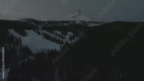 Aerial drone footage over a snow-covered volcanic mountain landscape with river valleys.
