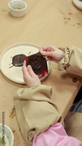 Child unmolding homemade chocolate candy piece