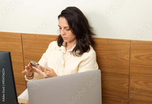 Young professional woman multitasking on her phone and computers