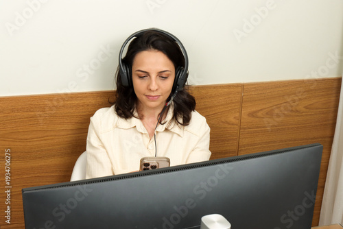 Young professional woman multitasking on her phone and computers