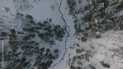 Aerial drone footage over a snow-covered volcanic mountain landscape with river valleys.