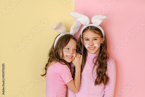 Obraz na plátně Funny laughing girl in the guise of pink Easter bunnies with a painted face