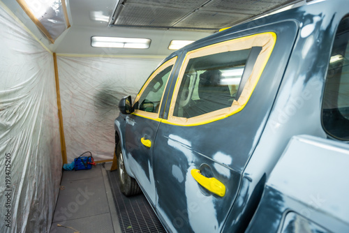 Photos Automotive service painting a vehicle in spray booth
