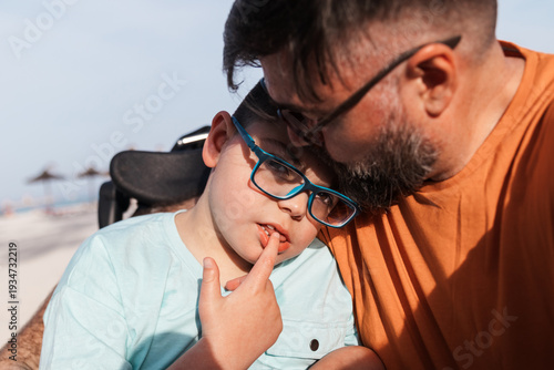 Tableau sur toile Father and young son with cerebral palsy in wheelchair, sharing a tender moment