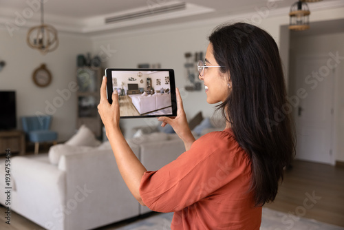 Obraz na płótnie Side view of smiling designer or realtor woman using digital tablet to take phot