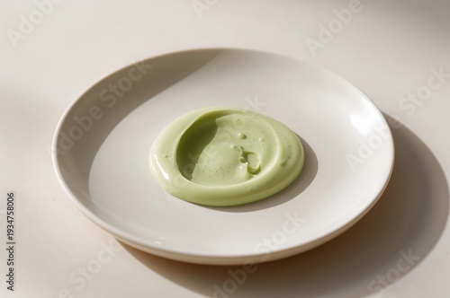 Wallpaper Mural Pale pistachio cream rests in glossy ribbon on matte white minimalist plate Torontodigital.ca