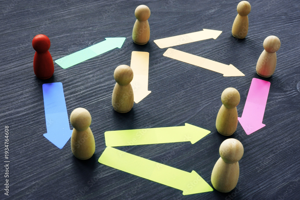 Obraz premium Flowchart of wooden pawns and colorful arrows on dark wooden surface, representing communication, collaboration, and connections in a network system.