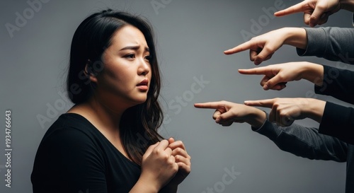 Upset woman, eyes wide, facing multiple accusing fingers