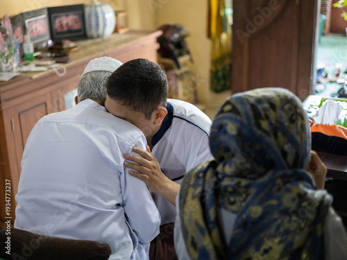 Tableau sur toile A touching moment of an Indonesian Muslim man traditionally asking for forgiveness (Sungkem) from his father during the Eid al-Fitr celebration