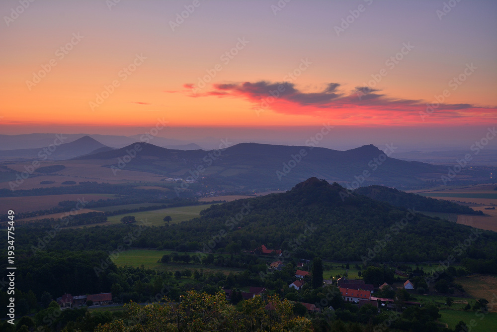 Obraz premium Vibrant Red Dawn over Bohemian Hills and Small Village