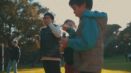 Group of children friends blowing soap bubbles in the park