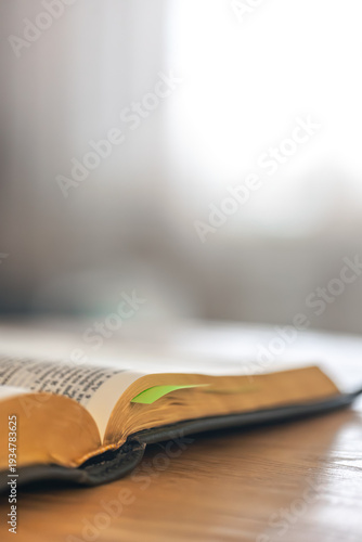 Open Bible in minimal interior for calm study and focus. Bible copyspace.