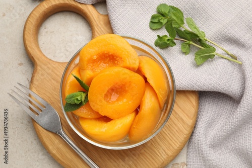 Obraz na plátně Pickled peaches and mint leaves in bowl on light grey table, flat lay