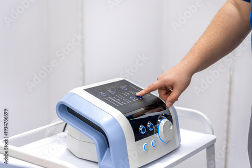 Bild auf Leinwand Doctor hand presses pressotherapy device control panel