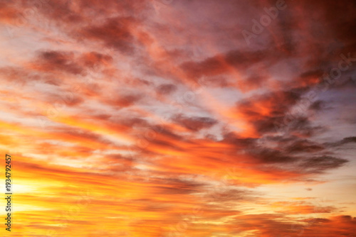 Quadro su tela Dramatic and colorful winter sunrise sky, with clouds filled with colors of orange, yellow, pink and purple, just before the sun rises at the dawn of a new day